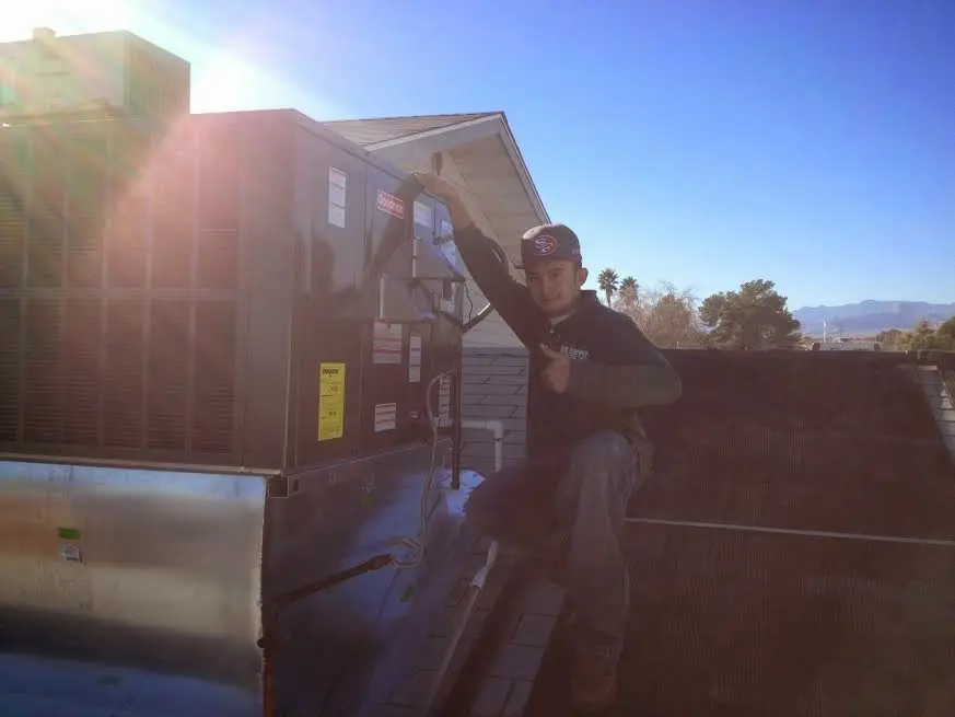 HVAC technician performing AC Tune-Up on a rooftop unit in New Britain